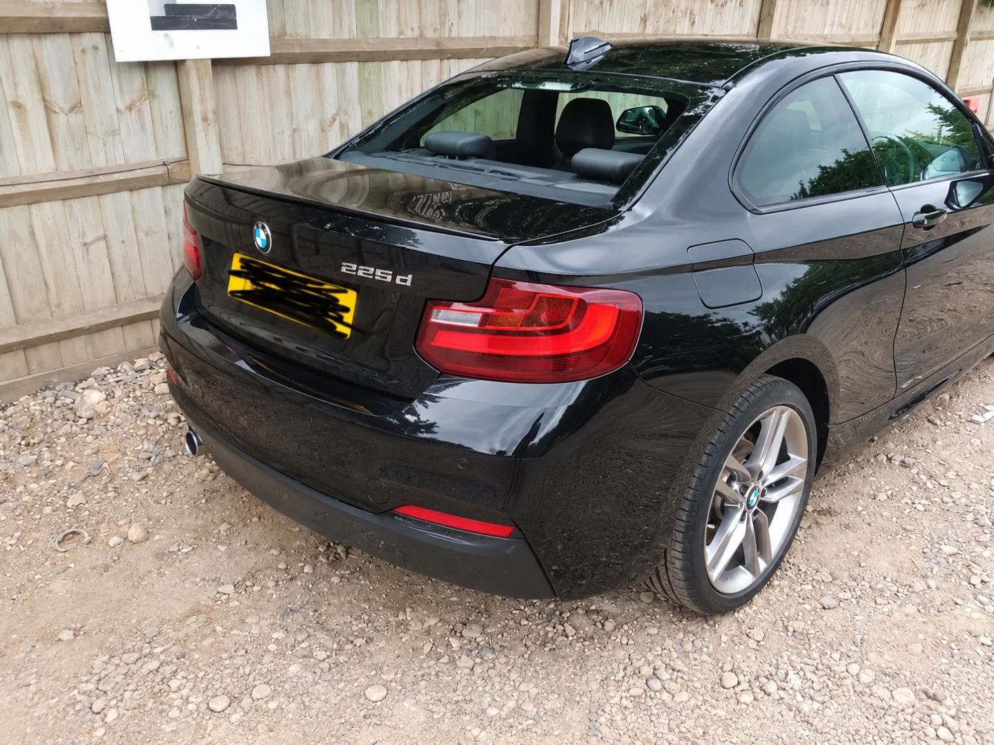 The same BMW 225d after repair, the rear quarter and bumper rebuilt and refinished in gloss black